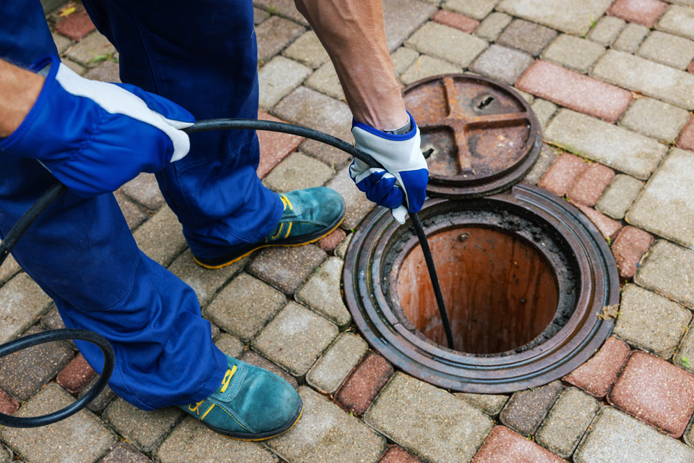 a plumber cleaning a blocked drain